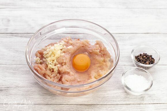 Добавьте яйцо, измельченный чеснок, соль и перец.