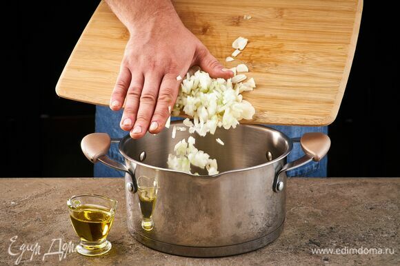 Влейте в кастрюлю оливковое масло и пожарьте лук и чеснок.