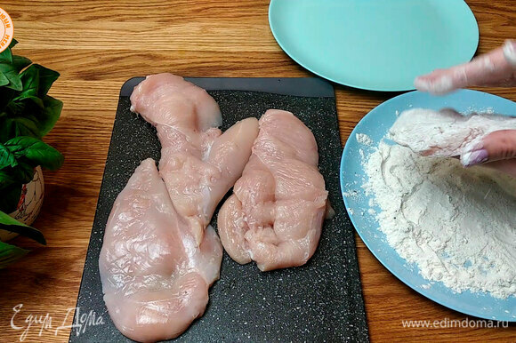 Куриное филе просушить и разрезать на две части. В муку добавить соль и перец, обвалять в ней филе.