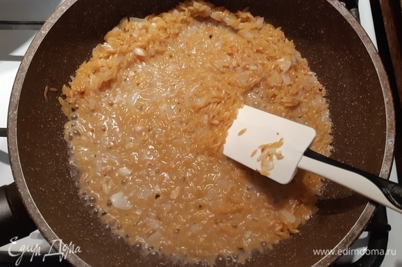 Вливаем кипяток, еле покрывая рис, и мешаем, постоянно размешивая. Как только вода впитается, нужно подлить еще воды. Примерное время приготовления риса — минут 20.