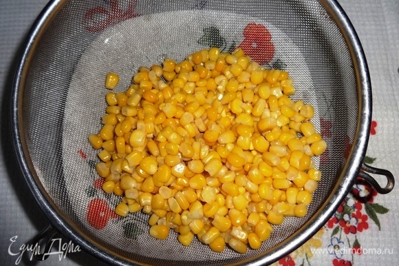Консервированную кукурузу выложить на дуршлаг, чтобы стекла жидкость.
