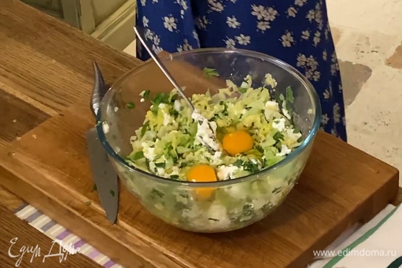 Выложить капусту в глубокую миску, добавить творог, 2 яйца и измельченную зелень, все посолить и перемешать.