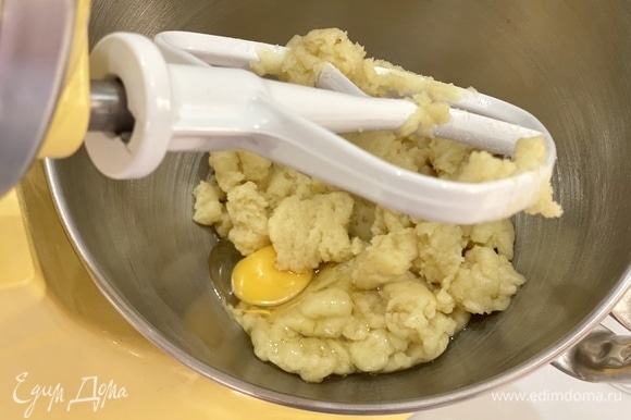 Переложить тесто в чашу миксера. Остудить 2 минуты. Перемешивая массу, постепенно добавлять по одному яйца.