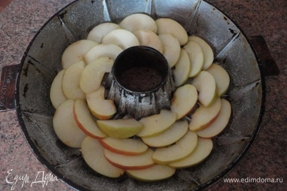 Дно формы смазать растительным маслом и посыпать панировочными сухарями или манной крупой. Яблоки выложить «чешуйкой» по кругу.