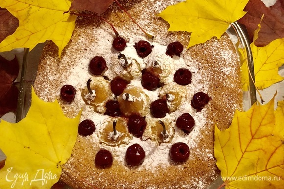 Готовый пирог посыпать сахарной пудрой и украсить ягодами вишни.