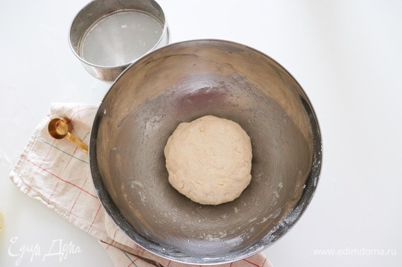 К муке добавляем соль, сахар, молоко и замешиваем тесто. Края емкости смазываем растительным маслом, кладем туда тесто и накрываем полотенцем. Оставляем тесто подниматься на 1,5 часа.