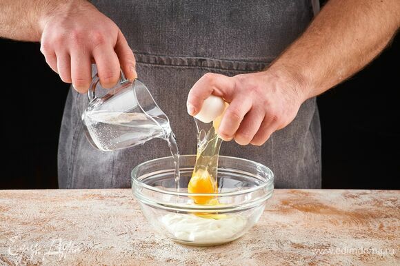 В миске смешайте яйцо, сметану и воду.