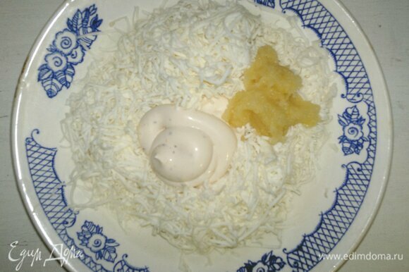 В миске соединить натертые сыр и чеснок, добавить майонез. Перемешать массу до однородности.