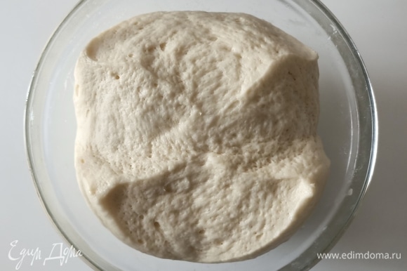 Переложить тесто в глубокую миску, накрыть пищевой пленкой и дать постоять примерно 1,5–2 часа при комнатной температуре. За это время тесто увеличится в объеме.