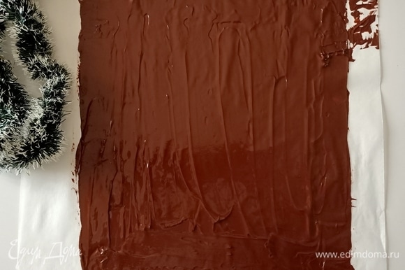 Шоколад измельчить и растопить на водяной бане. Выложить на пергаментную бумагу, распределить тонким слоем.