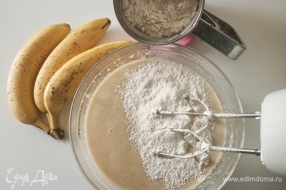 Уменьшить скорость миксера до минимума и добавить банановое пюре, затем — просеянную муку, разрыхлитель и соду.