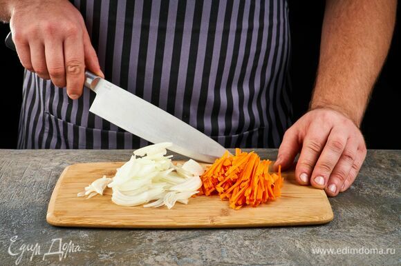 Нарежьте лук полукольцами, а морковь — тонкими брусочками.