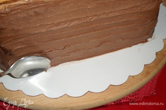 Вынимаем торт из холодильника. Ложкой делаем рисунок на шоколадной основе.