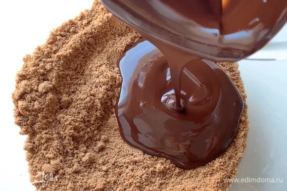 Влейте шоколад к печенью, перемешайте. Дно формы застелите пергаментом и выложите шоколадную основу.