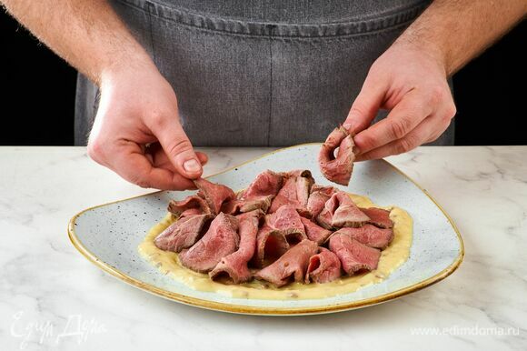 Готовое мясо остудите, тонко нарежьте. В тарелку налейте соус, выложите мясо.