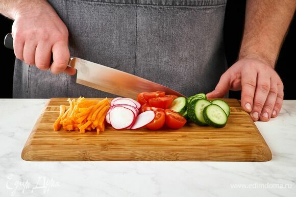 Морковь нарежьте тонкой соломкой, помидоры черри — пополам, редис — тонкими слайсами, огурец — кружочками.
