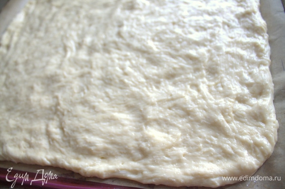 Смазать руки растительным маслом и растянуть тесто на противне с бумагой для выпечки. Это будет невысокий пирог.