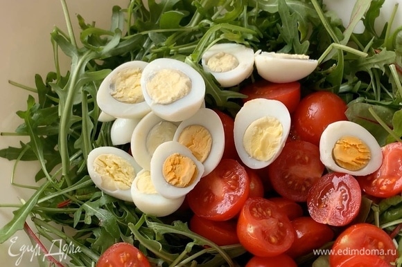 Отварите перепелиные яйца вкрутую, очистите, разрежьте пополам и положите в салатник.