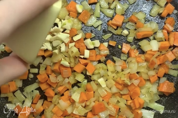В ту же сковороду с маслом выкладываем нарезанный лук и морковь, обжариваем 5–7 минут. Добавляем чеснок и томаты в собственном соку, накрываем крышкой и тушим около 5 минут.