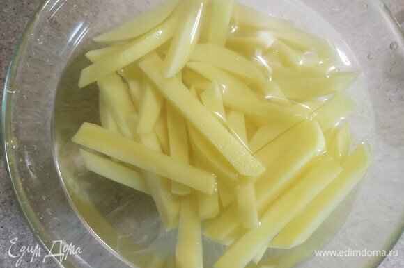 Очистить картофель и нарезать соломкой. Для того чтобы блюдо было хрустящим, необходимо промыть и замочить картофель на полчаса в ледяной воде.