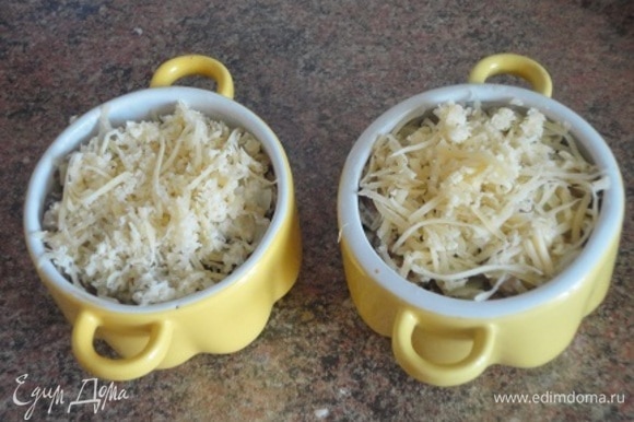 Сюда же в сковороду выложите грибы и перемешайте. Разложите по порционным формочкам и посыпьте тертым сыром.
