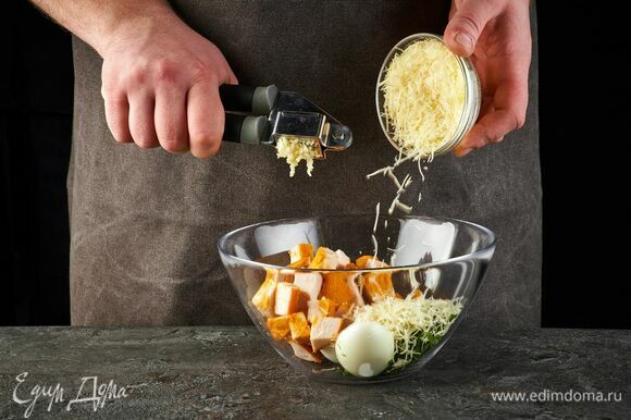 Выложите в салатник. Добавьте тертый сыр и выдавите чеснок.