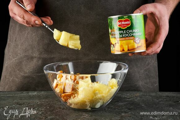 Откройте банку с кусочками ананаса в соке Del Monte, слейте жидкость. Добавьте в салатник.