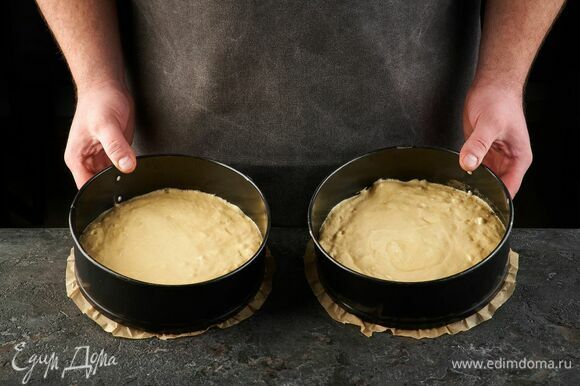 Дно двух форм диаметром 22 см застелите пекарской бумагой. Вылейте тесто и запекайте при 180°C около 30 минут, до сухой шпажки.