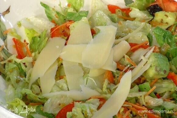 Твердый сыр нарезать тонкими хлопьями и выложить на салат.