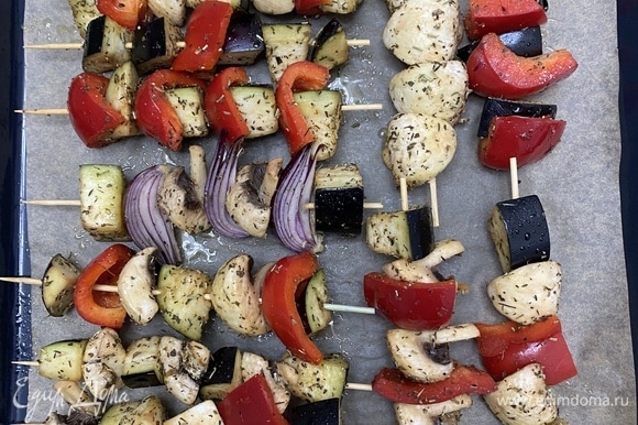 Нанизать овощи на шпажки, разложить на противень, застеленный пергаментом. Сбрызнуть оливковым маслом.