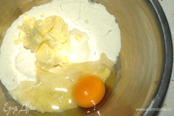 Муку с разрыхлителем просеять в миску, добавить размягченное сливочное масло, куриное яйцо, соль, сахар и молоко.