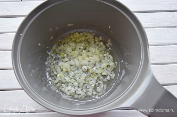 В кастрюлю с толстым дном влить растительное масло и пассеровать мелко нарезанный репчатый лук.