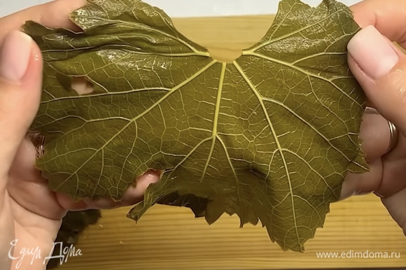 Виноградные листья промываем, отрезаем у каждого листика веточку. Рваные или не очень красивые листики выкладываем на дно кастрюли.