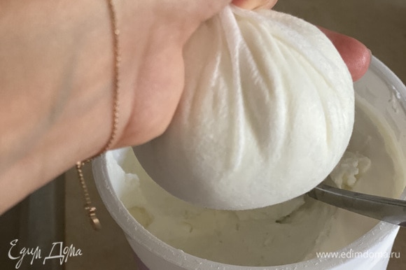 Греческий йогурт выкладываем в плотное полотенце или в несколько слоев марли. Берем небольшую часть, потому что отжимать 1 кг йогурта за один раз тяжело. Отжимаем что есть сил, чтобы убрать жидкость.