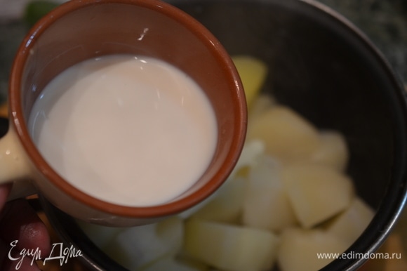 Когда картошка сварится, слейте воду. Добавьте сливочное масло и теплое молоко.