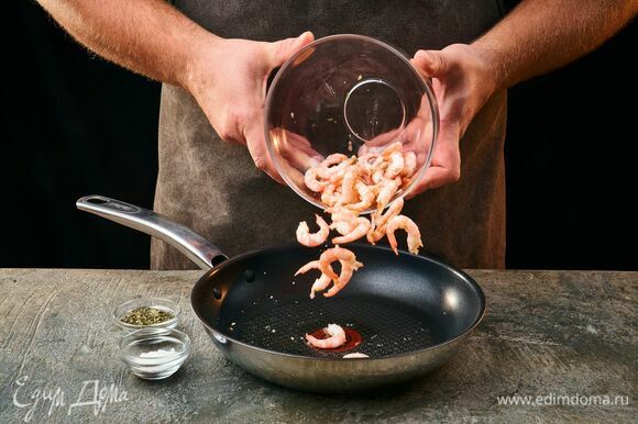 В разогретую сковороду влейте оливковое масло, обжарьте креветки с двух сторон, приправьте солью и прованскими травами. Обжаривайте креветки около 1 минуты.