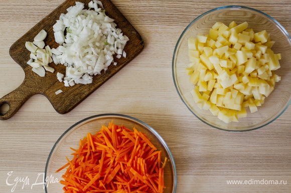 Морковь нарезать мелкой соломкой, картофель и лук — небольшими кубиками, а чеснок — пластинками.