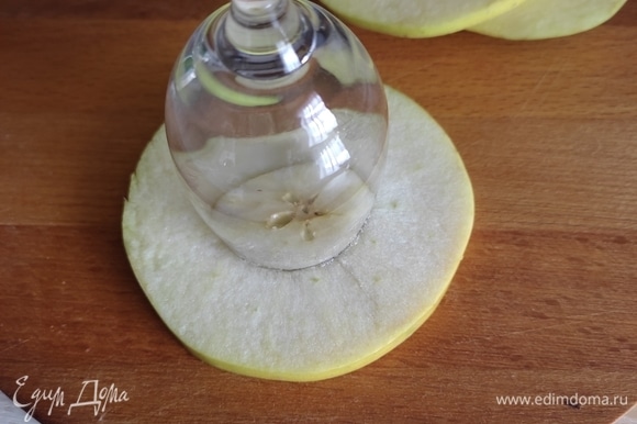 Рюмкой подходящего размера сделать отверстие посередине яблока.