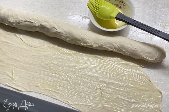 Далее раскатать тесто в пласт толщиной 0,5 мм. Смазать растопленным сливочным маслом. Свернуть в плотный рулет.