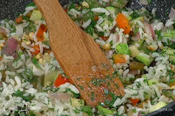 Отваренный рис выложить в сковороду с овощами, добавить орехи с изюмом и измельченную зелень, все перемешать и немного прогреть.
