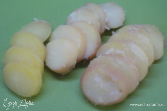 Сваренный в соленой воде картофель в мундире очистить и нарезать кружочками. Лук нарезать тонкими кольцами или полукольцами.