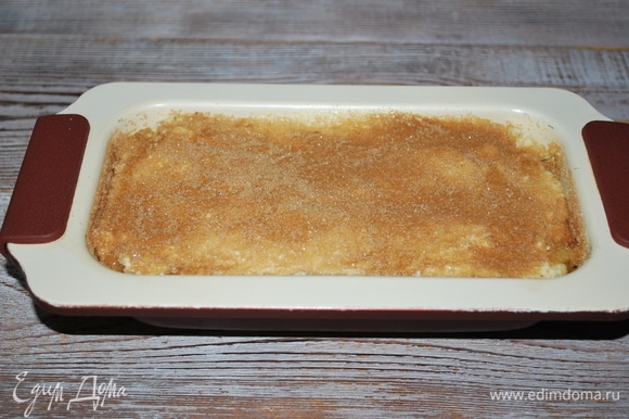 На яблоки — оставшееся тесто. Разровняйте поверхность заготовки с помощью лопатки. Верх пирога посыпьте сахаром с корицей. Выпекайте при 170°C примерно 40 минут, до готовности.