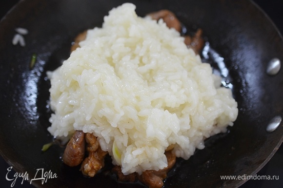 В сковороду к мясу добавьте рис.