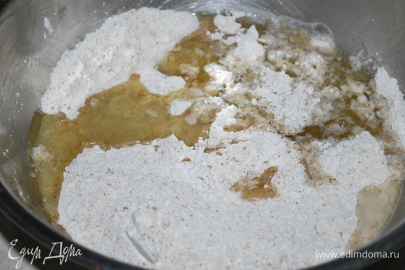 В миске смешайте ржаную и пшеничную муку, добавьте разрыхлитель, соль и сахар. В чашку налейте оливковое масло и кипяток, размешайте и влейте в муку.