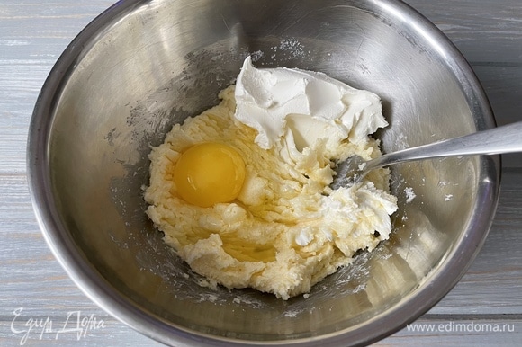Добавьте творожный сыр и куриное яйцо.