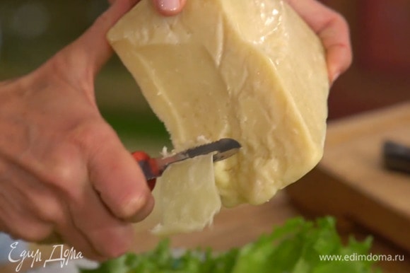 Сыр при помощи овощечистки нарезать тонкими хлопьями.