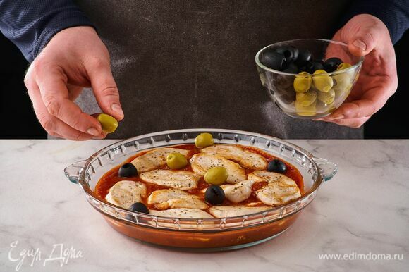 Выложите в форму для запекания овощной соус, сверху — куриное филе, слегка утопив в соусе. Добавьте оливки.