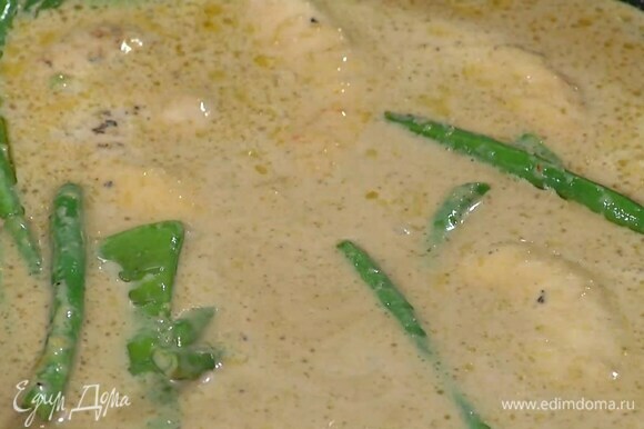 Влить в сковороду соевый соус, Nam Pla, кокосовое молоко и тушить курицу до готовности.