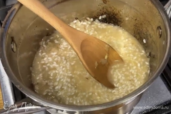 Влить горячий бульон, так чтобы он едва покрывал рис с луком. Тушить все вместе, активно помешивая. По мере выпаривания жидкости добавлять новую порцию бульона. Приправить блюдо мускатным орехом.