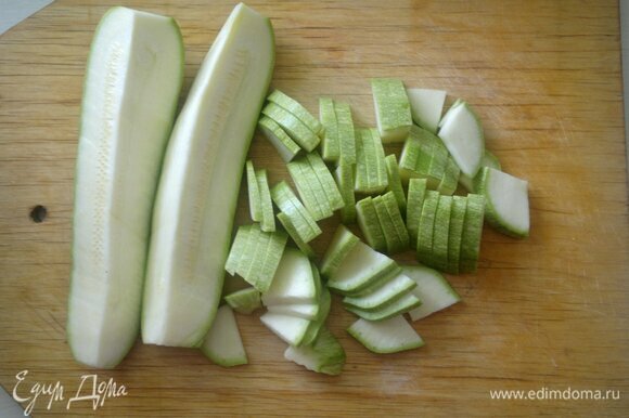 Кабачок вымойте и обсушите. Разрежьте овощ вдоль на четыре части и нарежьте его тонкими пластинами